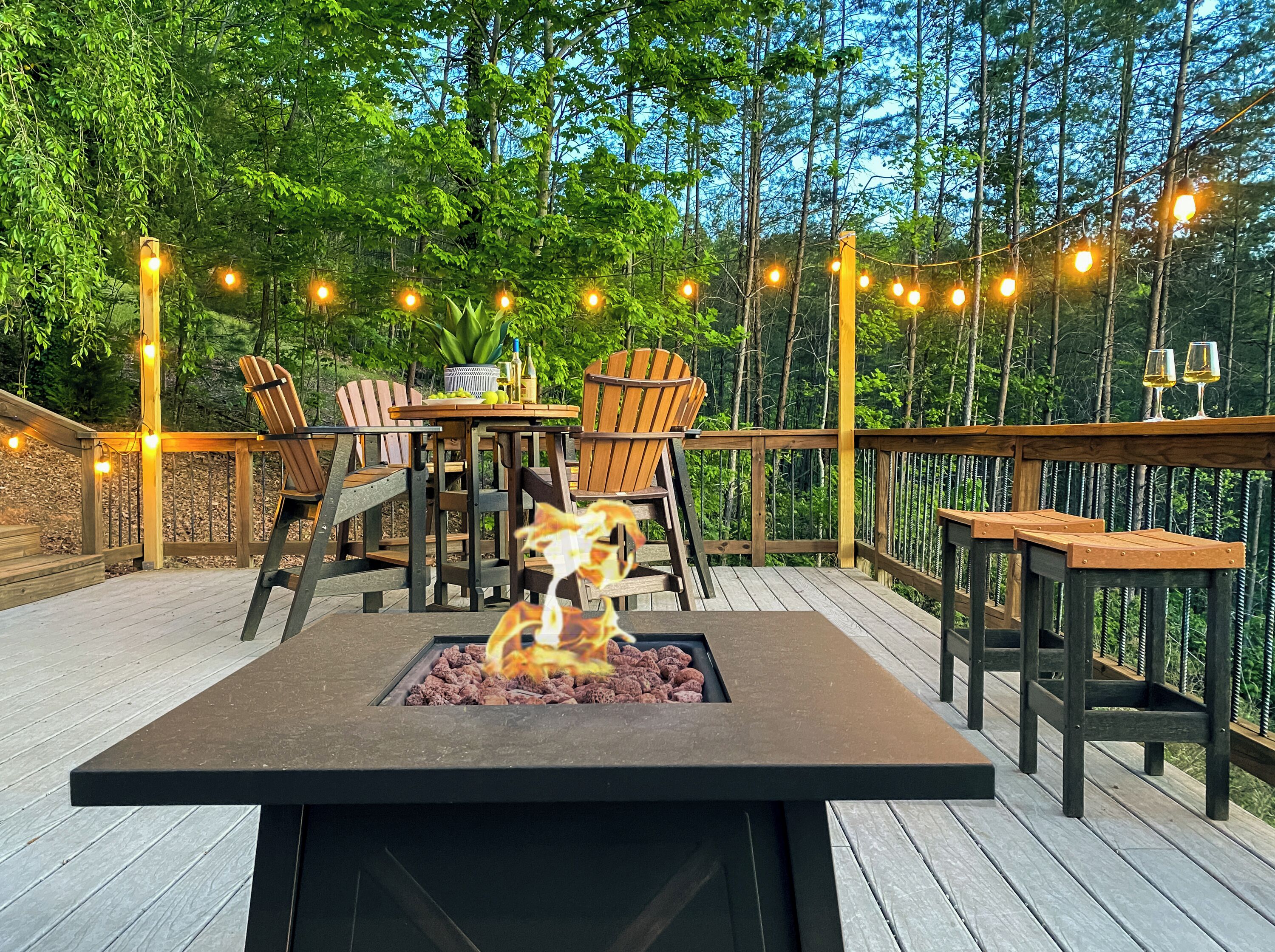 A deck with a fire pit, wooden chairs, and a table set for dining.