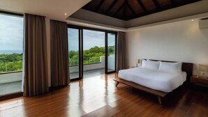 A modern bedroom with a large bed, wooden flooring, and a balcony with a view of greenery. - Vivo P Villa by Betterplace (Kutuh)