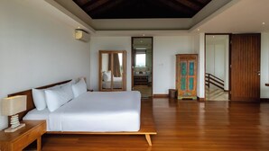 A spacious bedroom with a large bed, wooden flooring, a wooden ceiling, and a view of a bathroom and staircase. - Vivo P Villa by Betterplace (Kutuh)