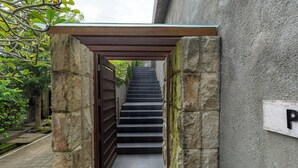 A stone staircase leading to a covered entrance, with a sign indicating a parking area. - Vivo P Villa by Betterplace (Kutuh)