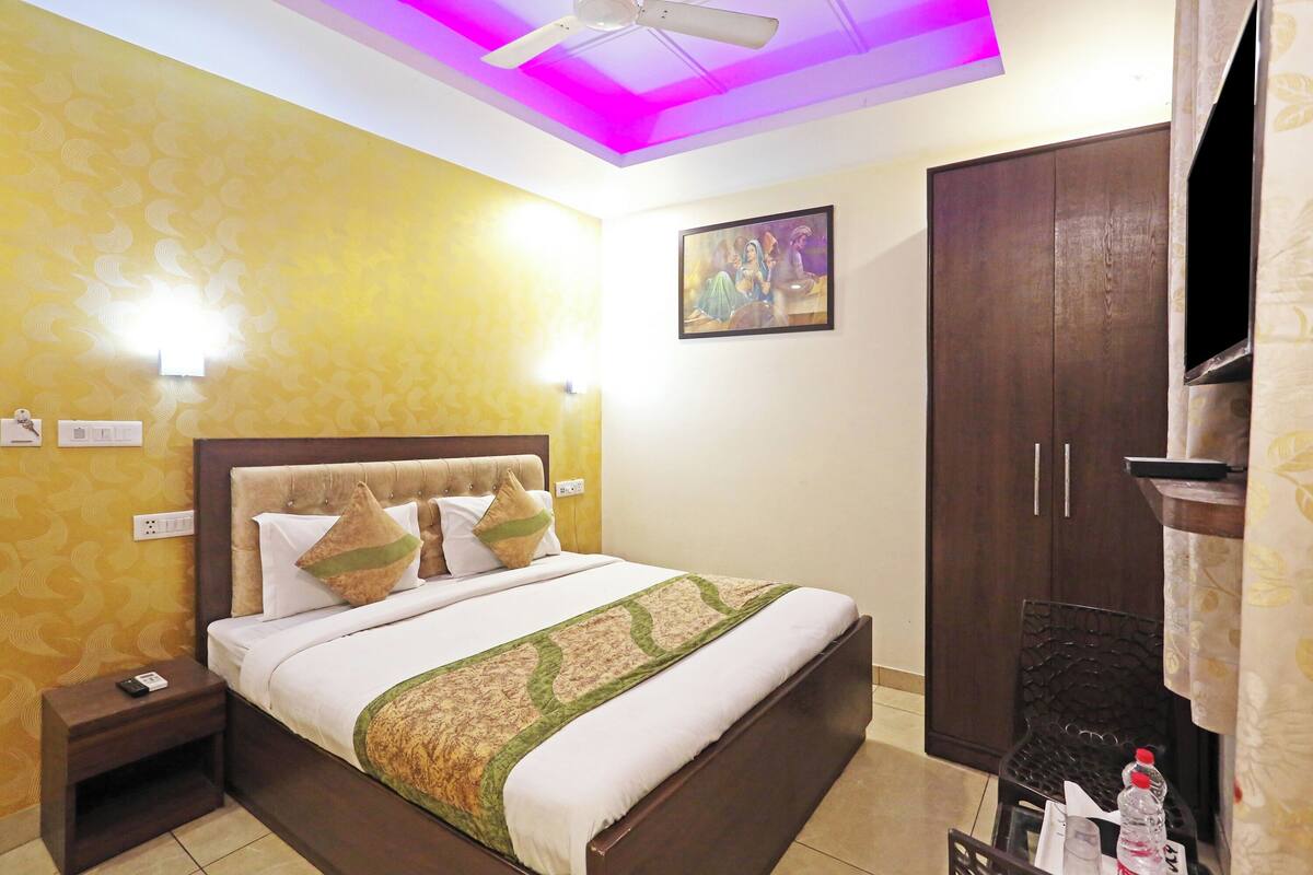 A hotel room with a bed, nightstand, wardrobe, and a ceiling fan.