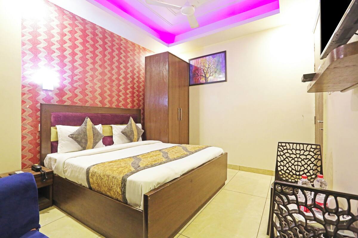 A bedroom with a bed, wardrobe, and a chair.