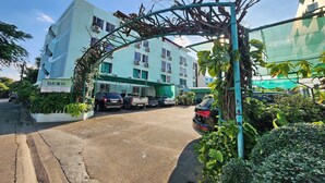 A multi-story building with a sign reading "GREEN APARTMENT." - Green Apartment Kaset (Bangkok)