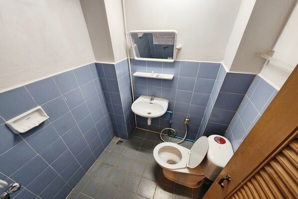 Un baño pequeño con inodoro, lavamanos y espejo.