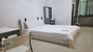 A bedroom with a bed, a desk, a chair, and a wardrobe. - Green Apartment Kaset (Bangkok)