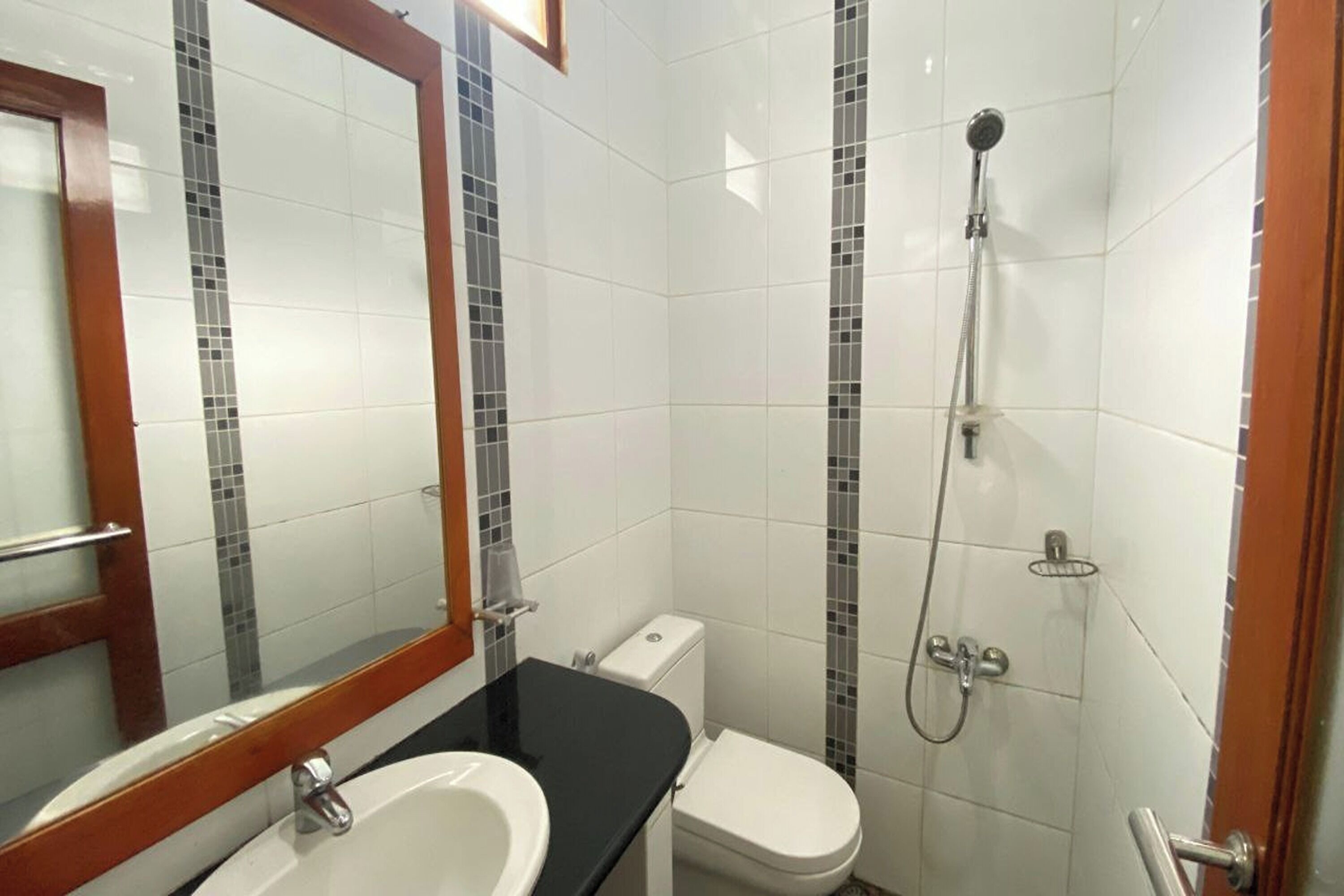 Ein Badezimmer mit einem weißen Waschbecken, einer Toilette und einer Dusche.