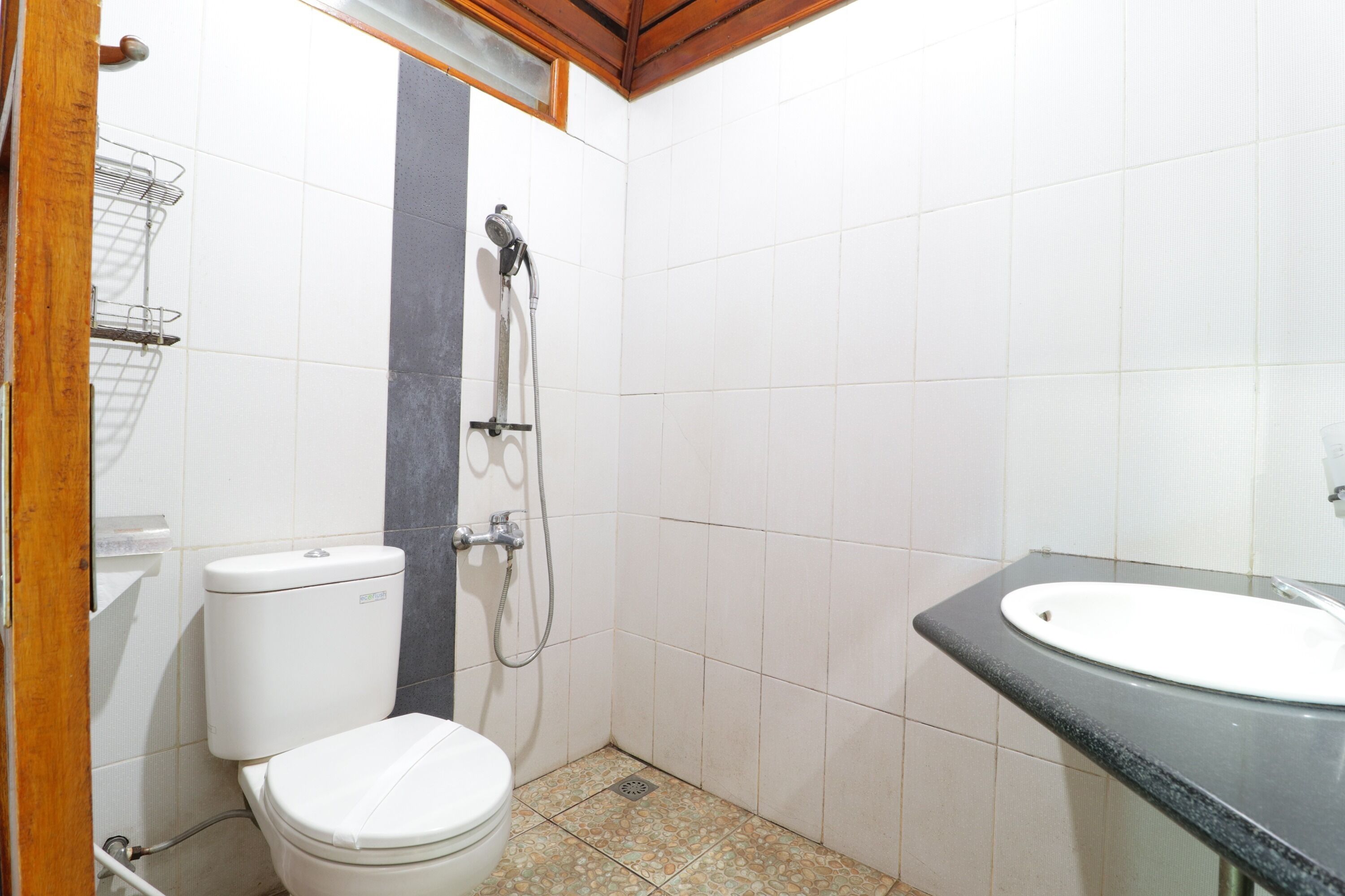 A small bathroom with a toilet, a shower, and a sink.
