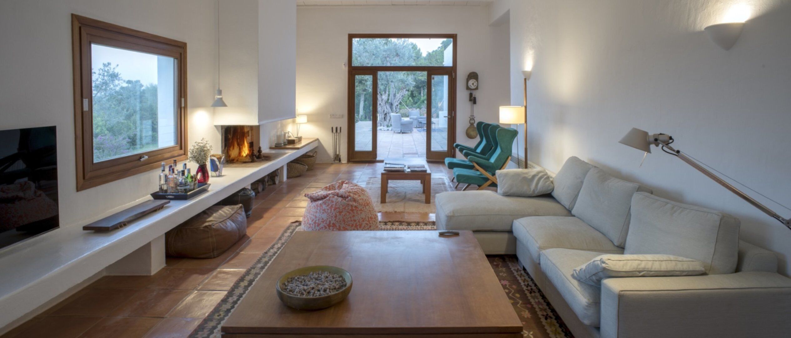 A living room with a fireplace, a sofa, a coffee table, and a television.