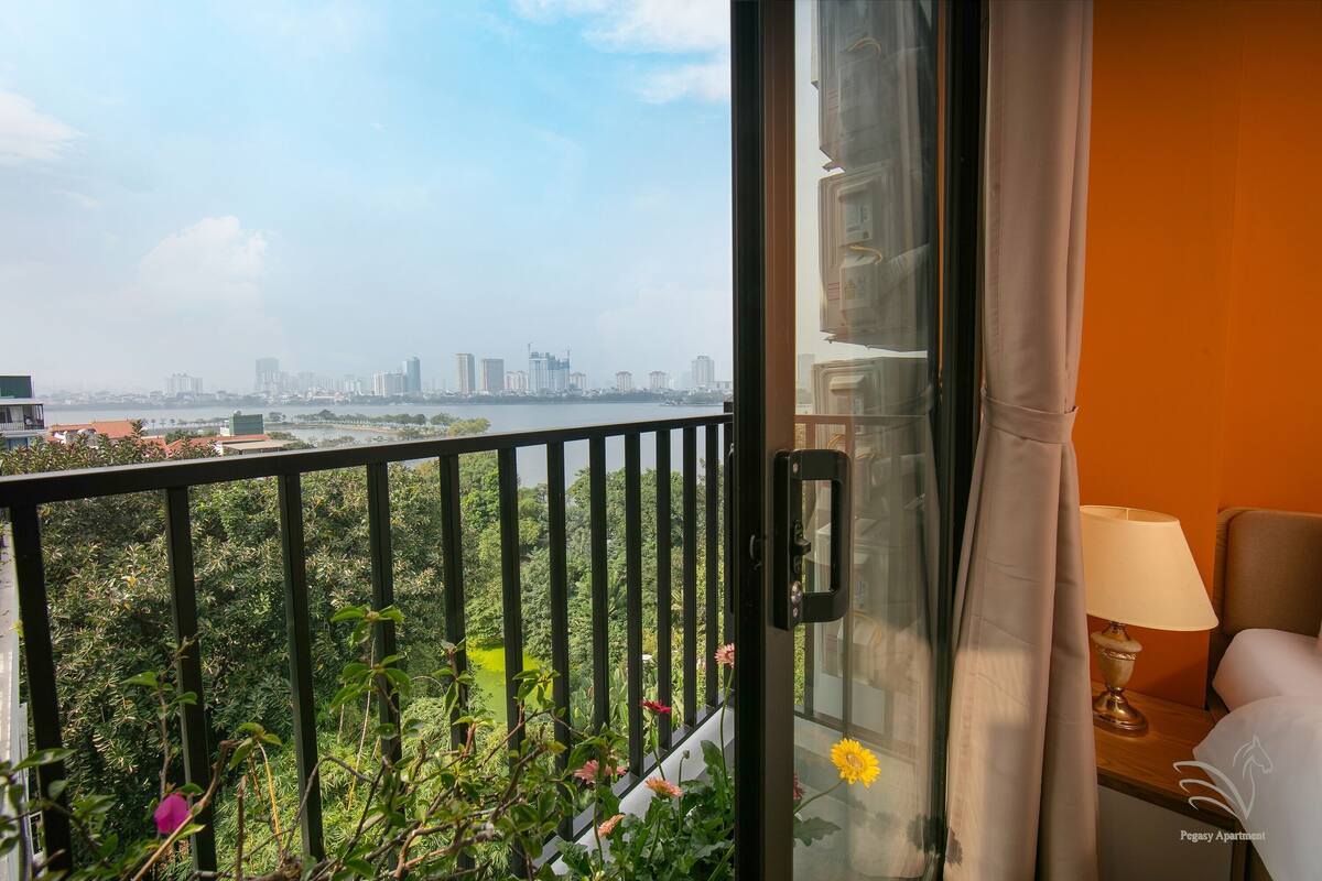 Une chambre d’hôtel avec vue sur les toits de la ville et sur une rivière.