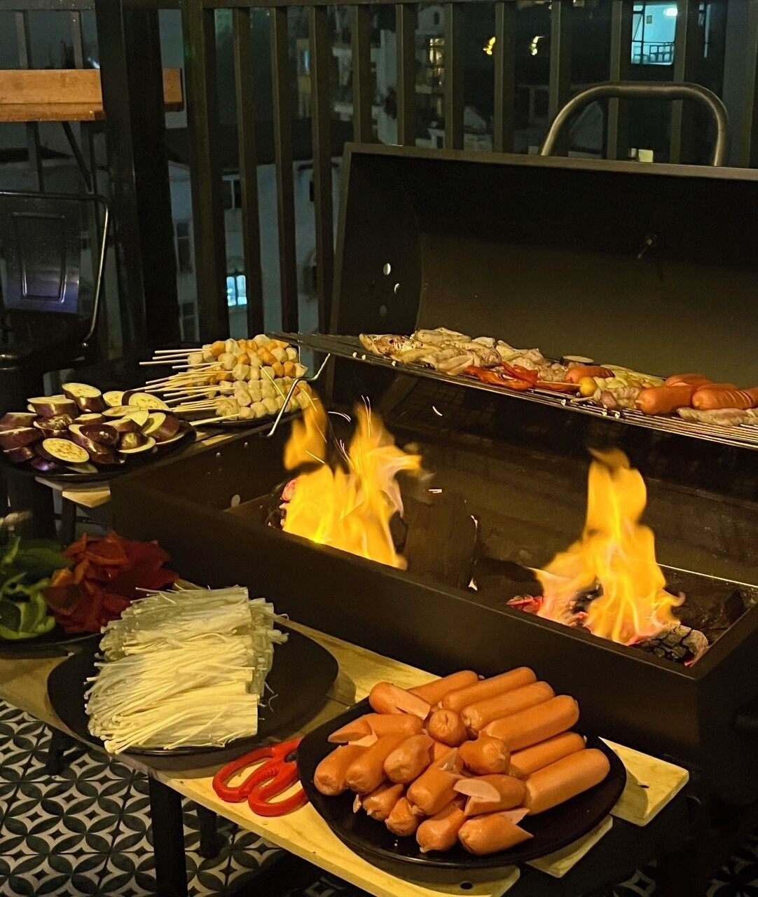 A grill with various meats and vegetables being cooked.