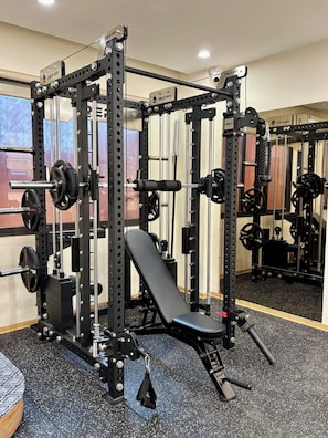 A gym with a squat rack, bench press, and various weight plates. - Westlake Pearl Aparthotel & Spa - By Pegasy Group (Hanoi)