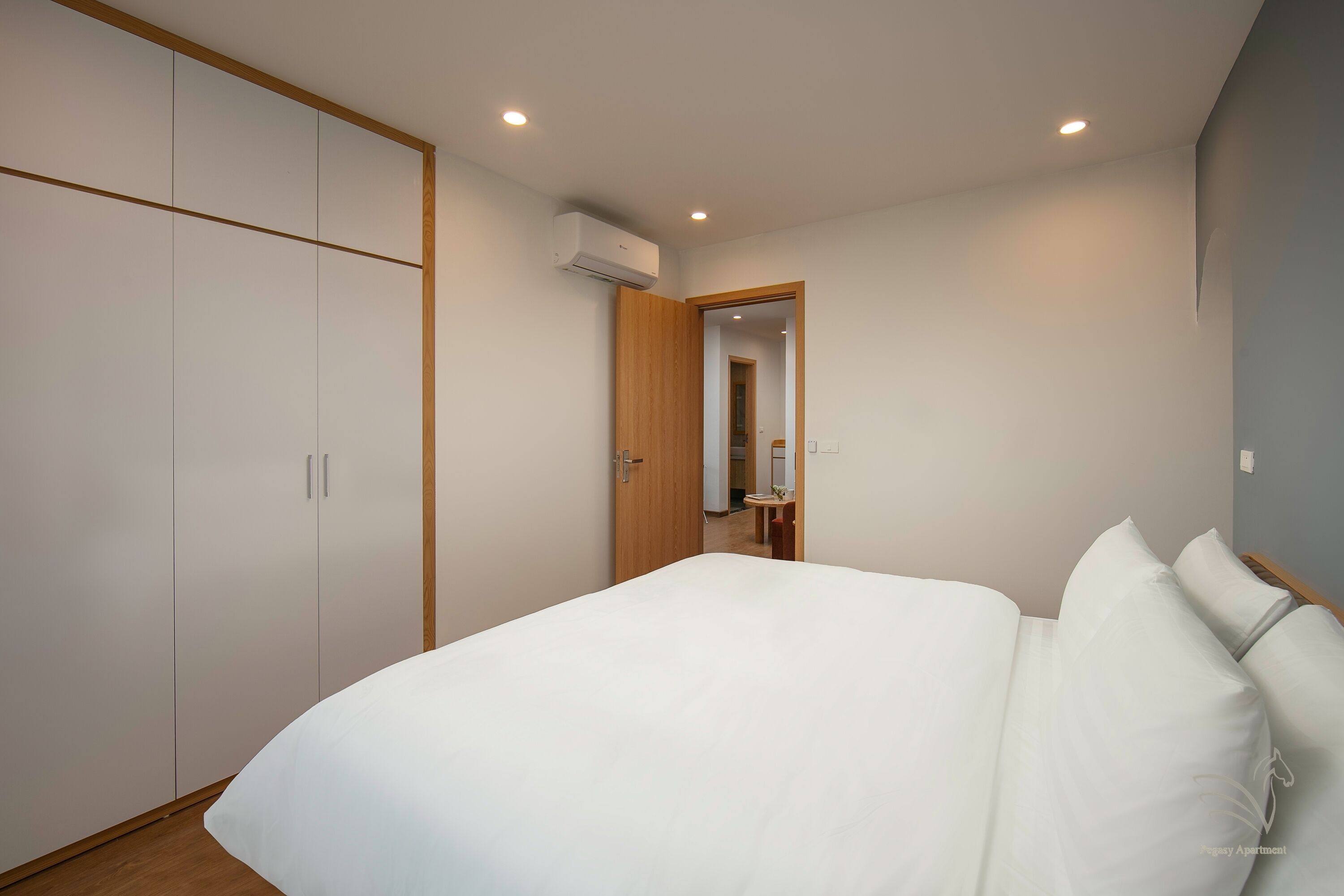Une chambre avec un grand lit, une armoire et un appareil de climatisation.