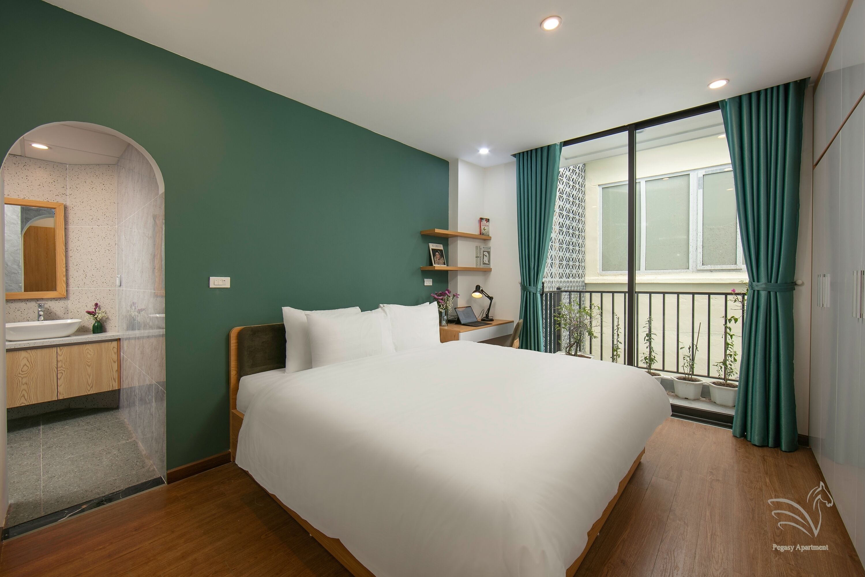 Una camera da letto con un letto grande, un bagno con un lavandino e vista sull'esterno da una finestra.