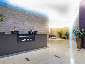 A reception desk with a sign for 'CASINO TOWERS' and 'DAKS' managed by 'Proudly Managed By.'