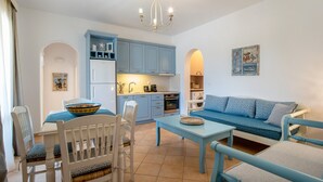 Een compacte woonruimte met een eethoek, kitchenette en een slaapbank.