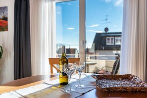 Una mesa con una botella de vino, dos copas de vino y una cesta tejida.