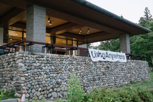 A building with a stone wall and a banner reading "Living Anywhere".