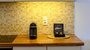 Een keuken met een betegelde spatwand, een koffieapparaat en een Nespresso koffiemachine op het aanrecht.