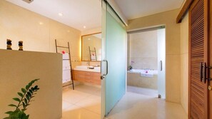 A modern bathroom with a glass partition, a sink, and a mirror.