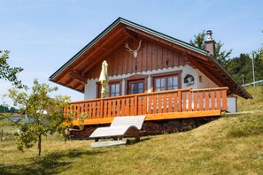 A wooden chalet with a balcony, a chimney, and a deer head decoration. - Holiday Home 'Kasimirs Alm Lodge' 55 sqm, 1 Bedroom, max. 4 Guests (Seebach)