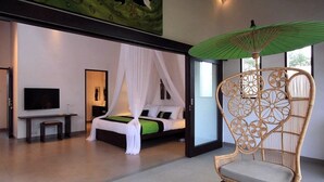 A modern bedroom with a bed, a television, and a wicker chair.