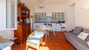 Ett kompakt bostadsutrymme med ett litet kök, en matplats och en soffa.