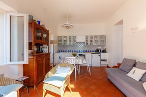 A compact living space with a kitchenette, a dining area, and a sofa.
