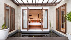 A modern bedroom with a bed centered in a glass enclosure, flanked by wooden doors and a small water feature in front. - Peaceful 16BR Villa W/ Pool in Bali, Bali Villa 2209 (Bali)