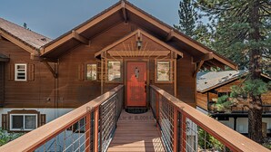 A wooden cabin with a covered porch, a wooden staircase, and a metal railing. - Overlooking the Slopes of Diamond (1236ST) (Incline Village)
