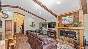 A cozy living room with a fireplace, a wooden ceiling, and a large window. - Overlooking the Slopes of Diamond (1236ST) (Incline Village)