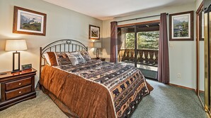 A bedroom with a large bed, two bedside tables, a window with curtains, and framed pictures on the walls. - Overlooking the Slopes of Diamond (1236ST) (Incline Village)