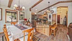 A spacious kitchen with wooden cabinets, a central island, and a dining area with a table and chairs. - Overlooking the Slopes of Diamond (1236ST) (Incline Village)