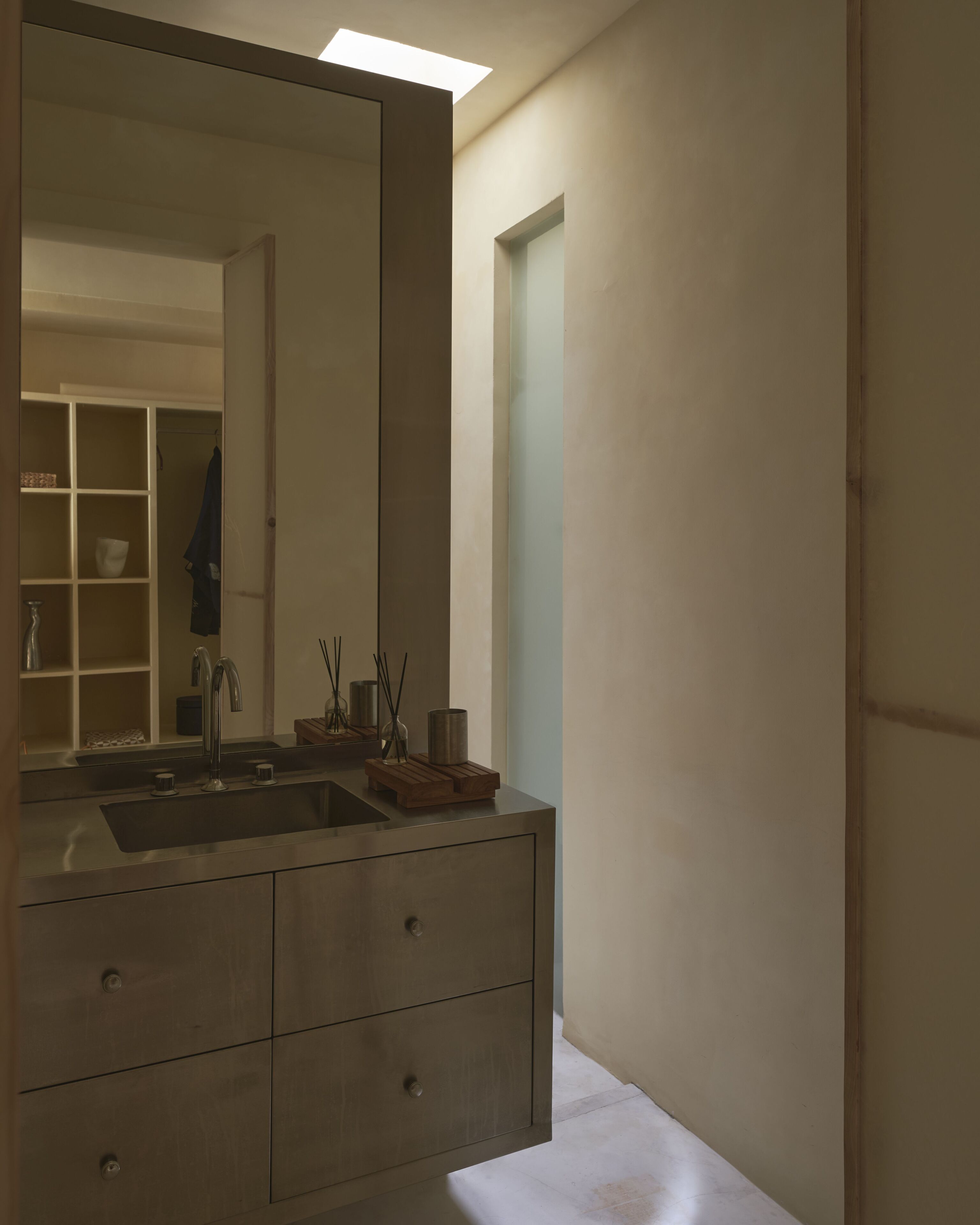 Un baño moderno con un espejo grande, un lavamanos y un mueble de tocador de madera.