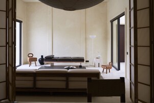 Una habitación con sofá, una silla, una mesita y una lámpara.