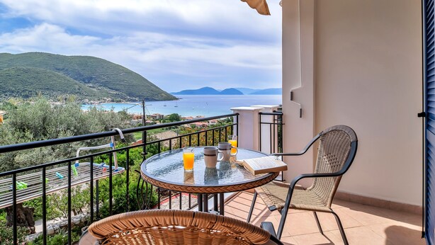 A balcony with a table, chairs, and a book. - Studio Apartment 'Panorama 2' with Sea View, Wi-Fi and Air Conditioning (Lefkada)