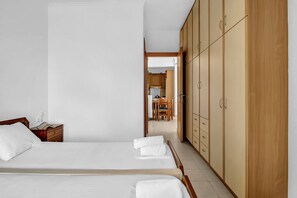 Une chambre d’hôtel avec deux lits, une armoire en bois et une vue sur la salle à manger.