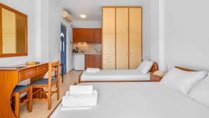 A bedroom with two beds, a desk, a chair, a wardrobe, and a kitchenette. - Studio Apartment 'Panorama 1' with Sea View, Wi-Fi and Air Conditioning (Lefkada)