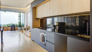 A modern kitchen with a large island, stainless steel appliances, and wooden cabinetry. - Designer SoHOPV w/th Ocean Views (Puerto Vallarta)
