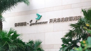 A hotel sign with Chinese characters and a stylized bird logo. - ZhouShan Poly Senbo Nature Park and Resort (Zhoushan)