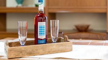 Eine Flasche Minammentu-Wein und zwei Gläser auf einer Holztischplatte.