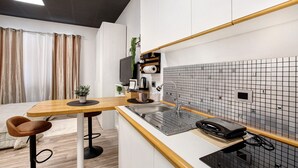Una cocina moderna con encimera de madera, un lavamanos y un salpicadero de azulejos negros.