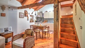 A wooden interior with a dining area, kitchen, and staircase.