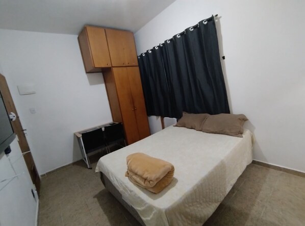 Restful retreat with a single bed, wardrobe, and desk for a functional space to work and unwind.