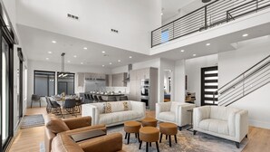 A spacious living area with a high ceiling, a dining area, and a kitchen. - Scenic Sunvilla Monthly Home| Private Pool, Hot Tub, Basketball Court (Hurricane)