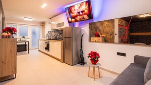A modern kitchen with a built-in oven, a refrigerator, and a dining area with a table and chairs. - Wellness & Relax Apartment Lilly, Trebnje, Slovenia (Trebnje)