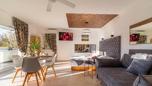 Un salon moderne comprenant un canapé, un coin repas et un téléviseur.