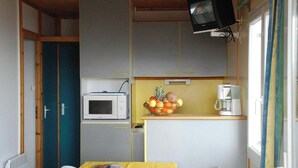 A compact kitchen with a microwave, a fruit bowl, and a coffee maker. - Chalet Gazania with Mountain View, Shared Pool, and Wi-Fi (Blavignac)