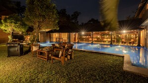 A backyard with a swimming pool, outdoor furniture, and a barbecue area. - Amã Stays & Trails Lily Pad , Kumarakom (Kottayam)