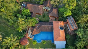 An aerial view of a house with a swimming pool, surrounded by lush greenery and palm trees. - Amã Stays & Trails Lily Pad , Kumarakom (Kottayam)
