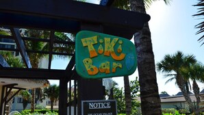Une enseigne indiquant un bar de style Tiki, avec un avis concernant la licence du club privé de The Ocean Village.
